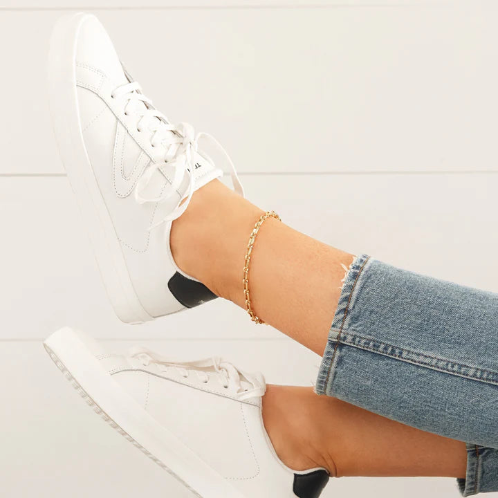 anklet on ankle with jeans and white shoes