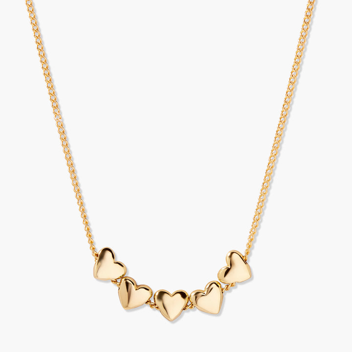 Posy Heart Necklace with five polished puffy hearts linked along a gold-tone chain.