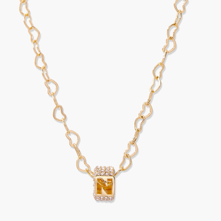 Initial letter charm necklace with a pavé crystal rectangular bead on a heart-link chain, close-up of a single customizable charm.