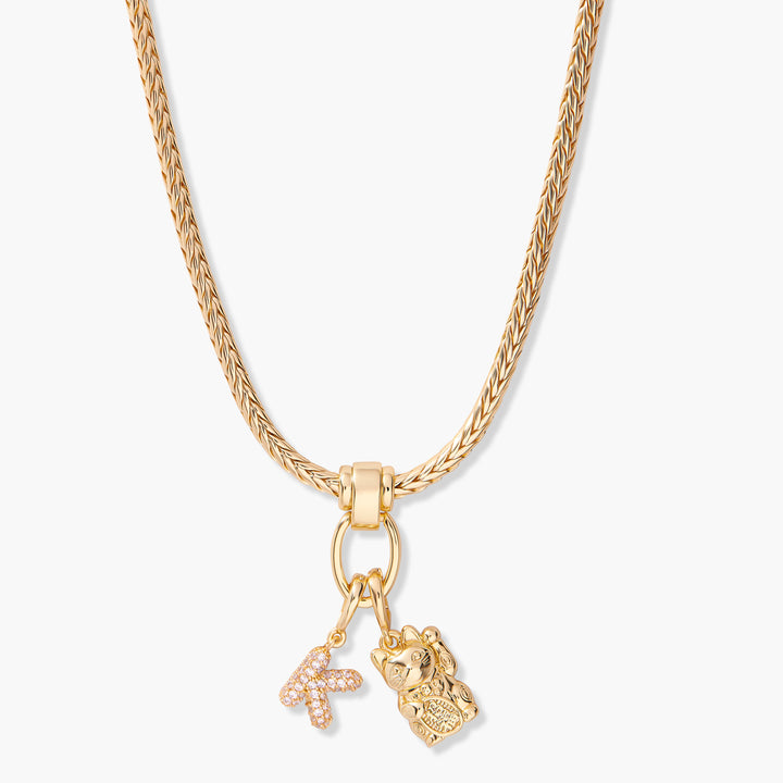 Charm necklace with a thick braided chain, ring clasp, pavé butterfly initial charm, and a lucky cat charm.