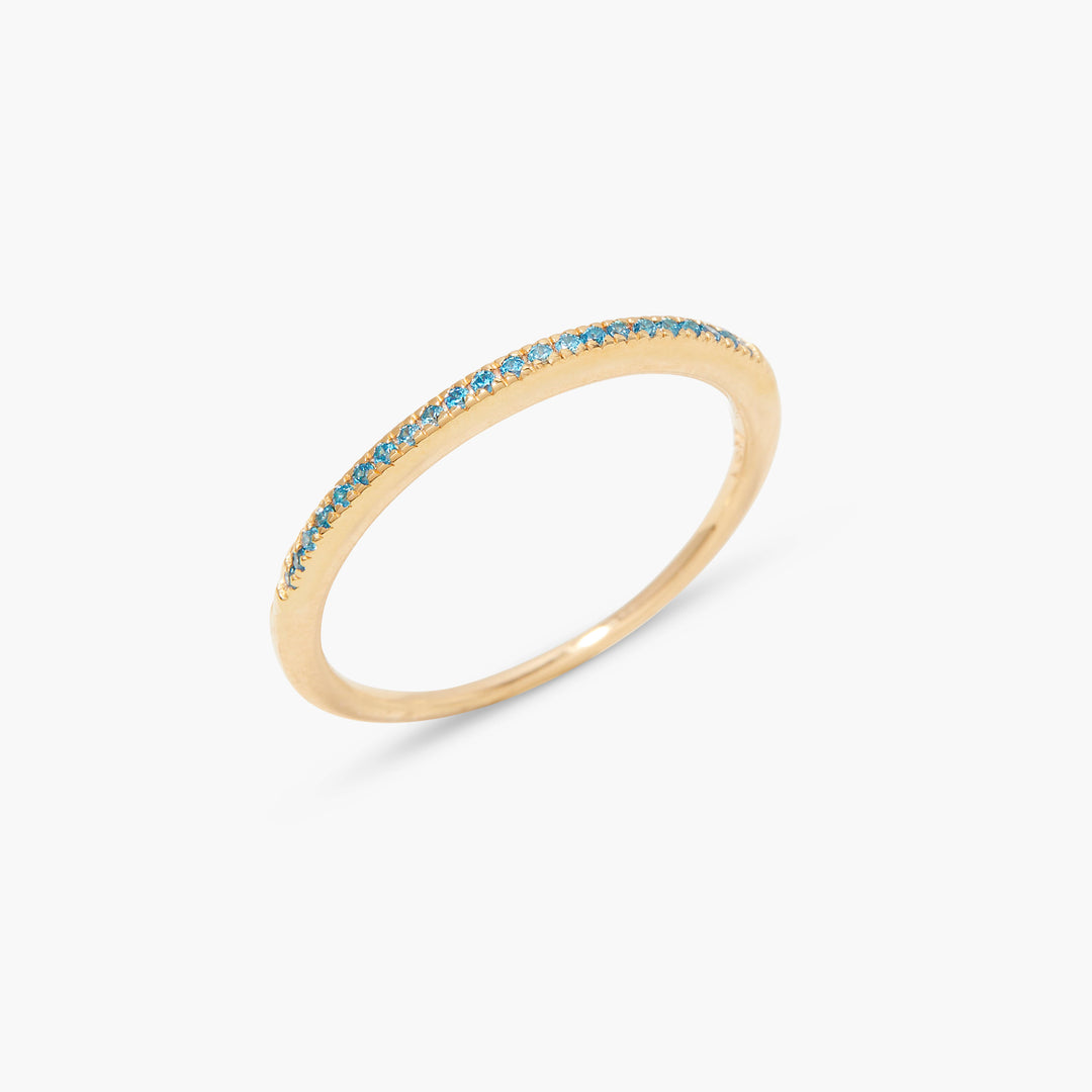 Slim eternity-style band ring with pavé-set blue stones along the front half, in a delicate stackable design.