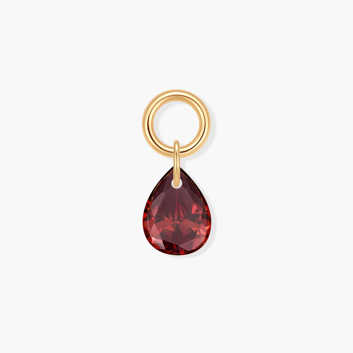 Gold-tone birthstone charm with a faceted red teardrop crystal suspended from a ring clasp.