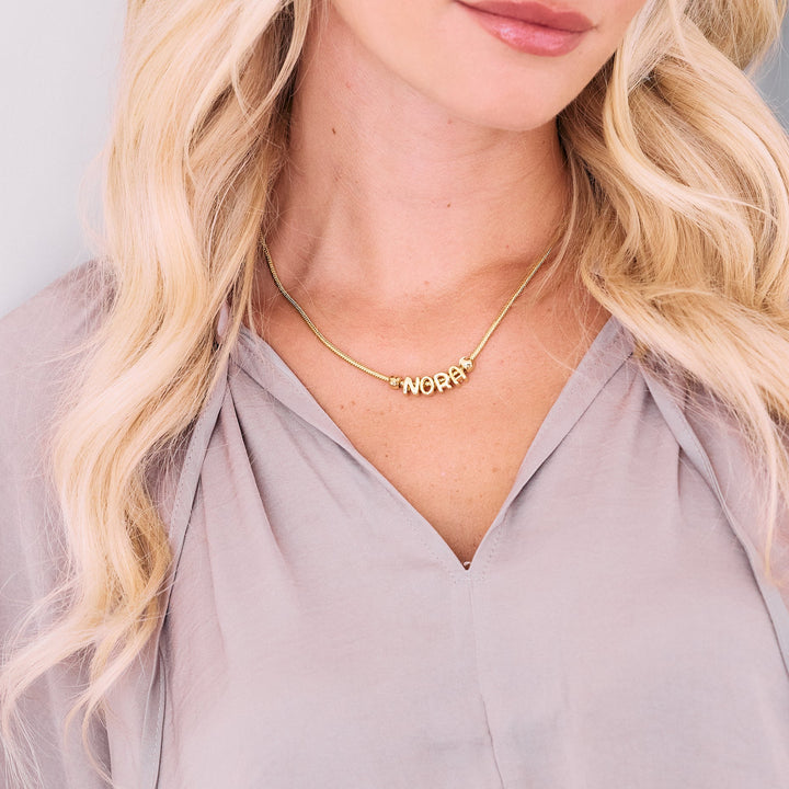 gold chain with letters spelling out a name.