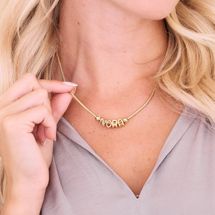 Breezy Name Chain Necklace with puffy custom letter beads on a chain, worn by a model.