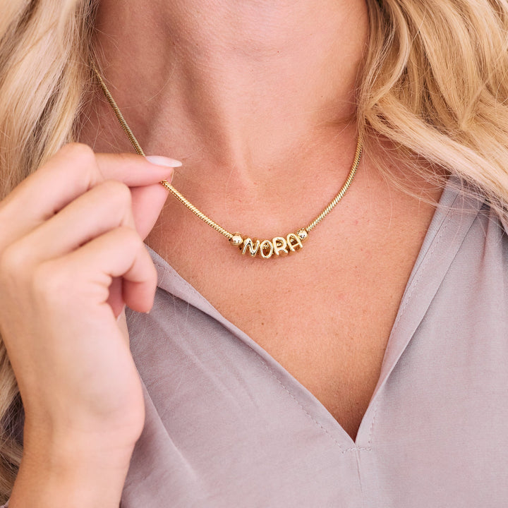 Breezy Name Chain Necklace with bubble-letter name beads on a chain, worn by a model.