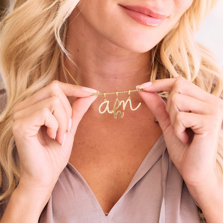 gold chain with gold and cz initials hanging from neck.